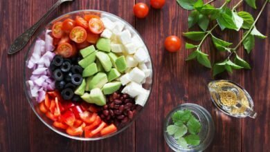 a bowl filled with vegetables and Salad Fork on top of a wooden table